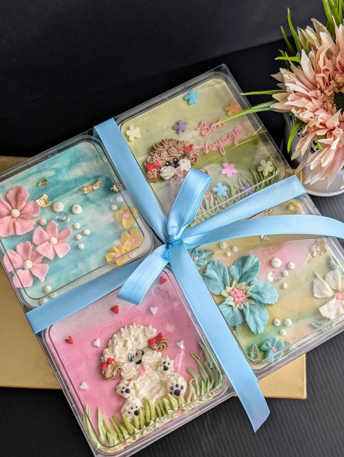 Floral bento boxed cakes with hand-piped buttercream flowers on pastel painted backgrounds, healthy low-sugar mini cakes Singapore
