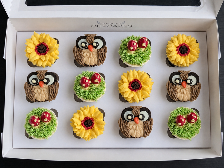 Box of 12 cupcakes inspired by woodlands forest design. there are 4 Sunflowers, 4 Owls and 4 Mushroom  cupcakes nestled in green buttercream grass