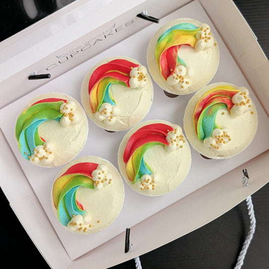Rainbow cupcake with hand-piped vibrant buttercream swirl and rainbow sprinkles