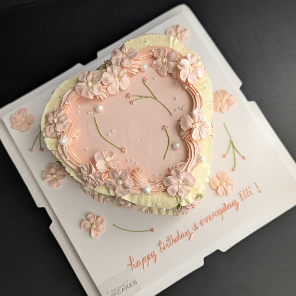 Heart-shaped vintage cake with blush pink buttercream ruffles, piped floral details and pearl accents, romantic low-sugar birthday cake Singapore