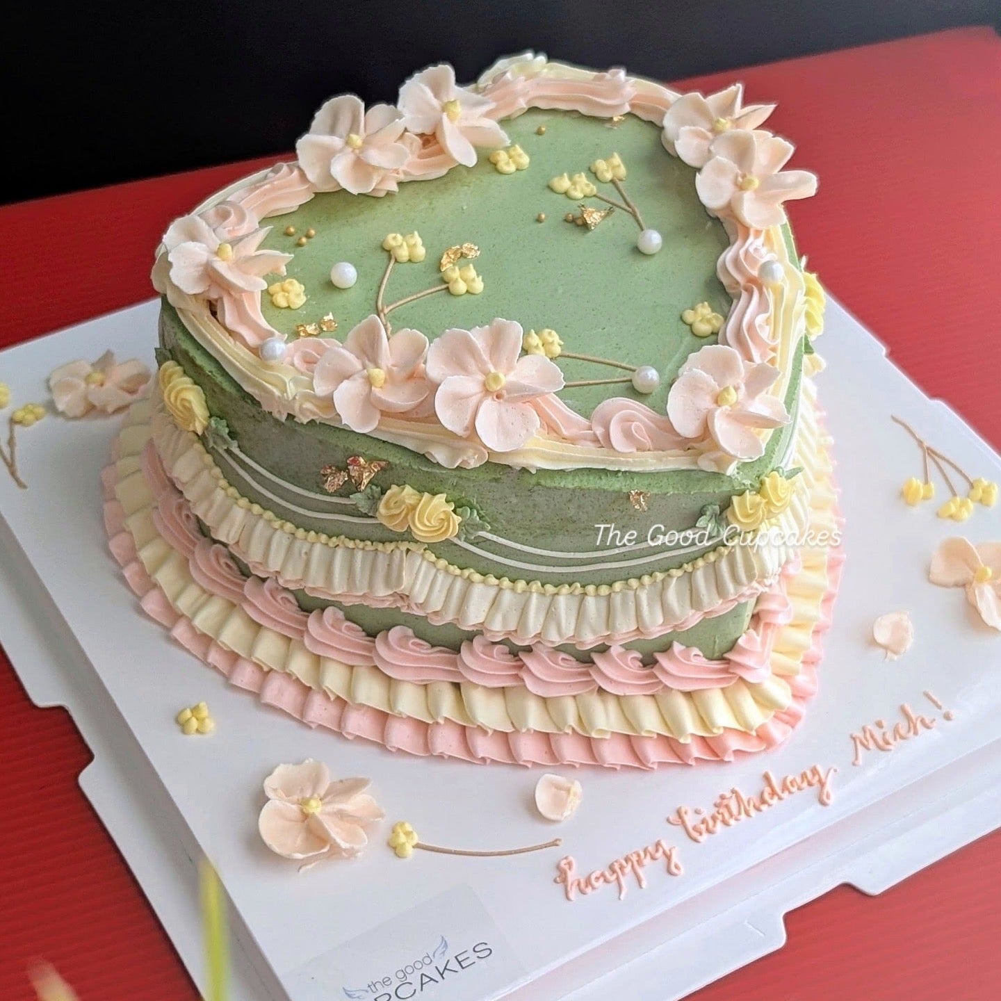 Heart-shaped vintage cake with blush pink buttercream ruffles, piped floral details and pearl accents, romantic low-sugar birthday cake Singapore