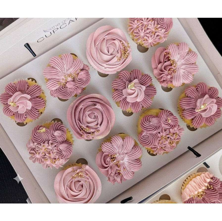 Box of 12 gender reveal cupcakes with hand-piped dusty pink floral buttercream in rose, chrysanthemum and petal fan designs with gold leaf and pearl sprinkles, The Good Cupcakes Singapore