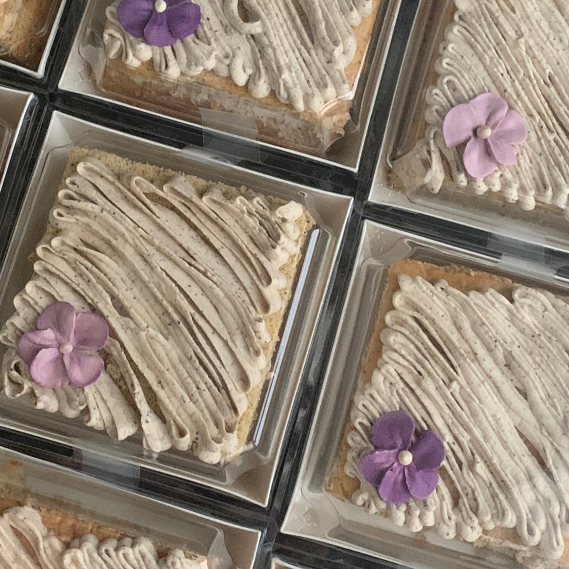 Earl Grey tea cake with swirled speckled buttercream and purple violet flower in clear gift box, healthy low-sugar cake Singapore