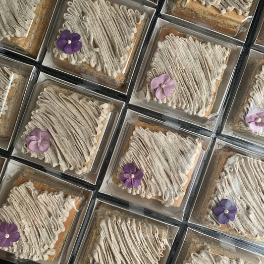 Earl Grey tea cake with swirled speckled buttercream and purple violet flower in clear gift box, healthy low-sugar cake Singapore