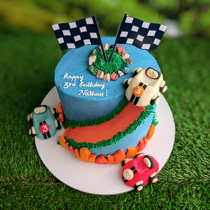 Car-themed birthday cake with baby blue buttercream, toy racing cars and road details, low calorie, no fondant