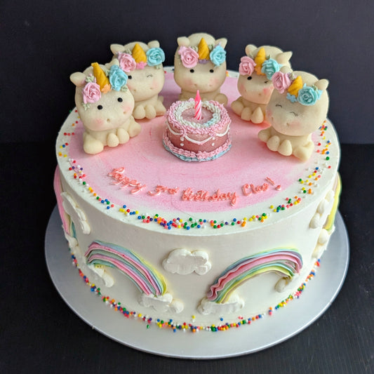 Round unicorn birthday cake with white buttercream, rainbow drip and sprinkles, two hand-sculpted unicorn toppers and “Happy Birthday” script — The Good Cupcakes Singapore