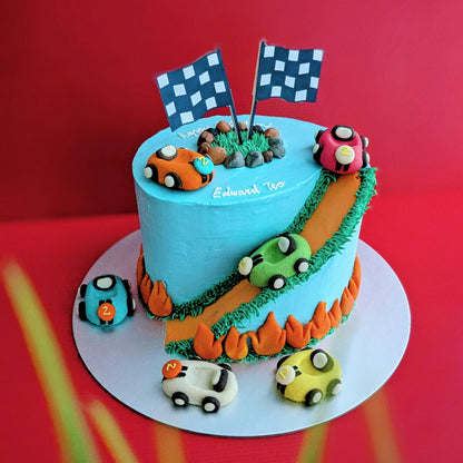 Car-themed birthday cake with baby blue buttercream, toy racing cars and road details, low calorie, no fondant
