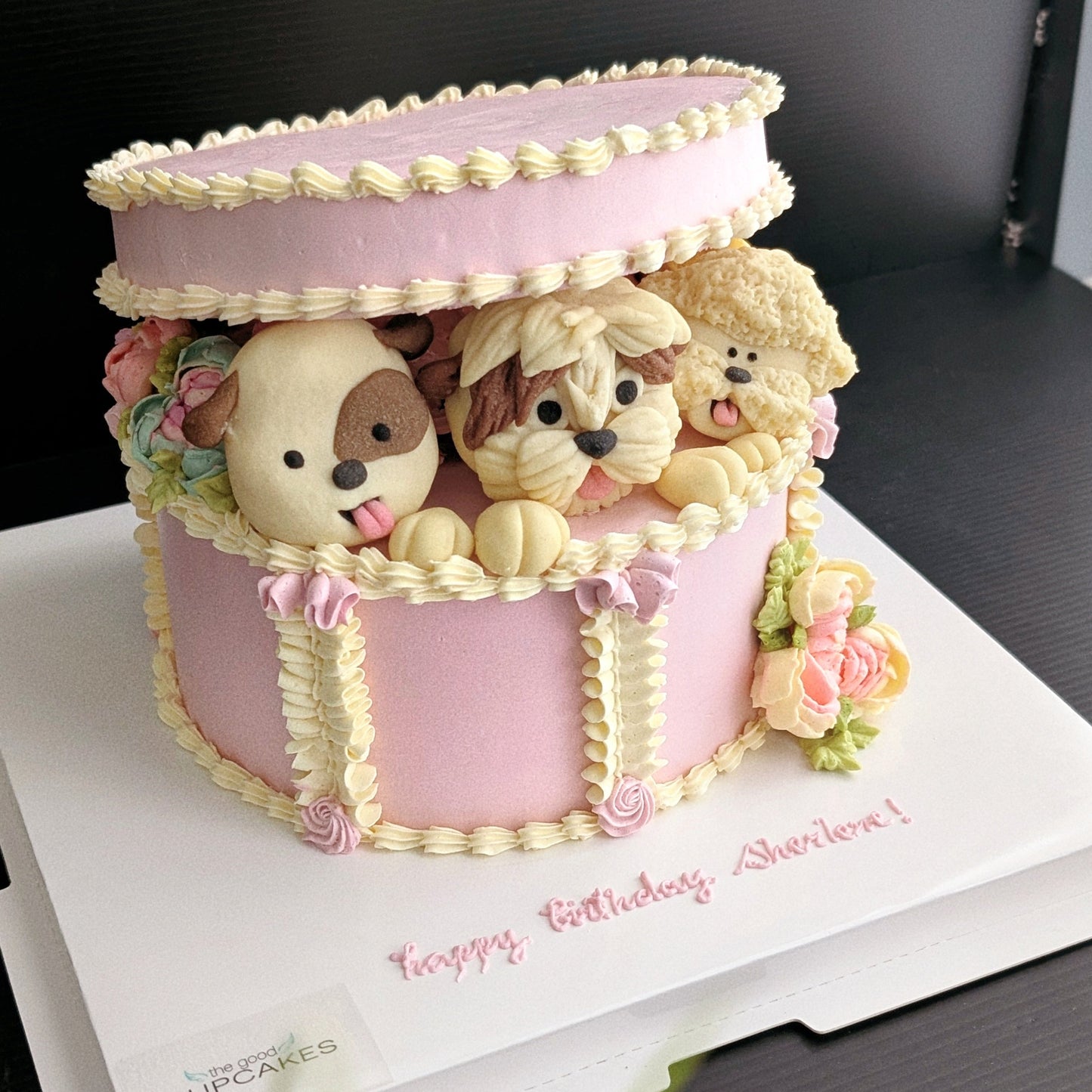 Gift box with 3 puppies in a hand-piped white and pink cake gift box, healthy low-sugar birthday cake
