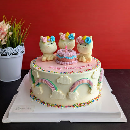 Side view of unicorn birthday cake displayed on a stand with rainbow drip, styled with fresh greenery — The Good Cupcakes Singapore