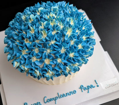 Giant cupcake cake shaped like oversized cupcake with blue hydrangea buttercream top and white ribbed base, low-sugar celebration cake Singapore