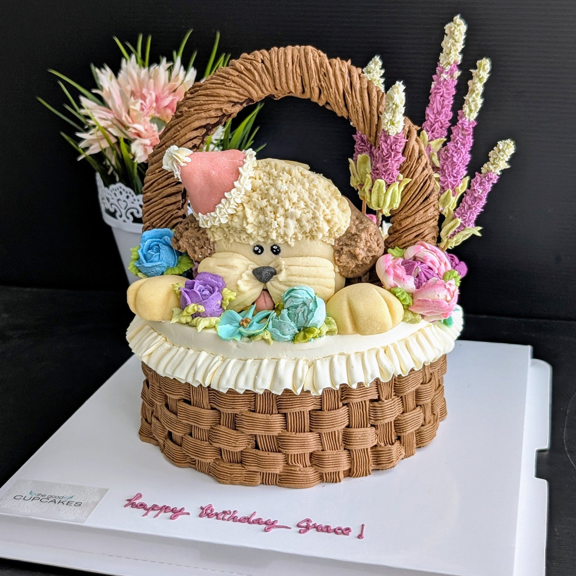 Floral basket cake with a sculpted puppy surrounded by hand-piped purple, pink and yellow flowers healthy low-sugar birthday cake