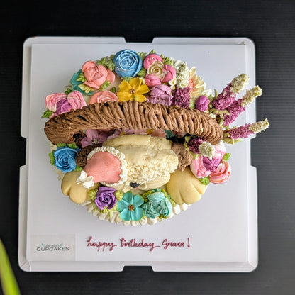 Floral basket cake with a sculpted puppy surrounded by hand-piped purple, pink and yellow flowers healthy low-sugar birthday cake