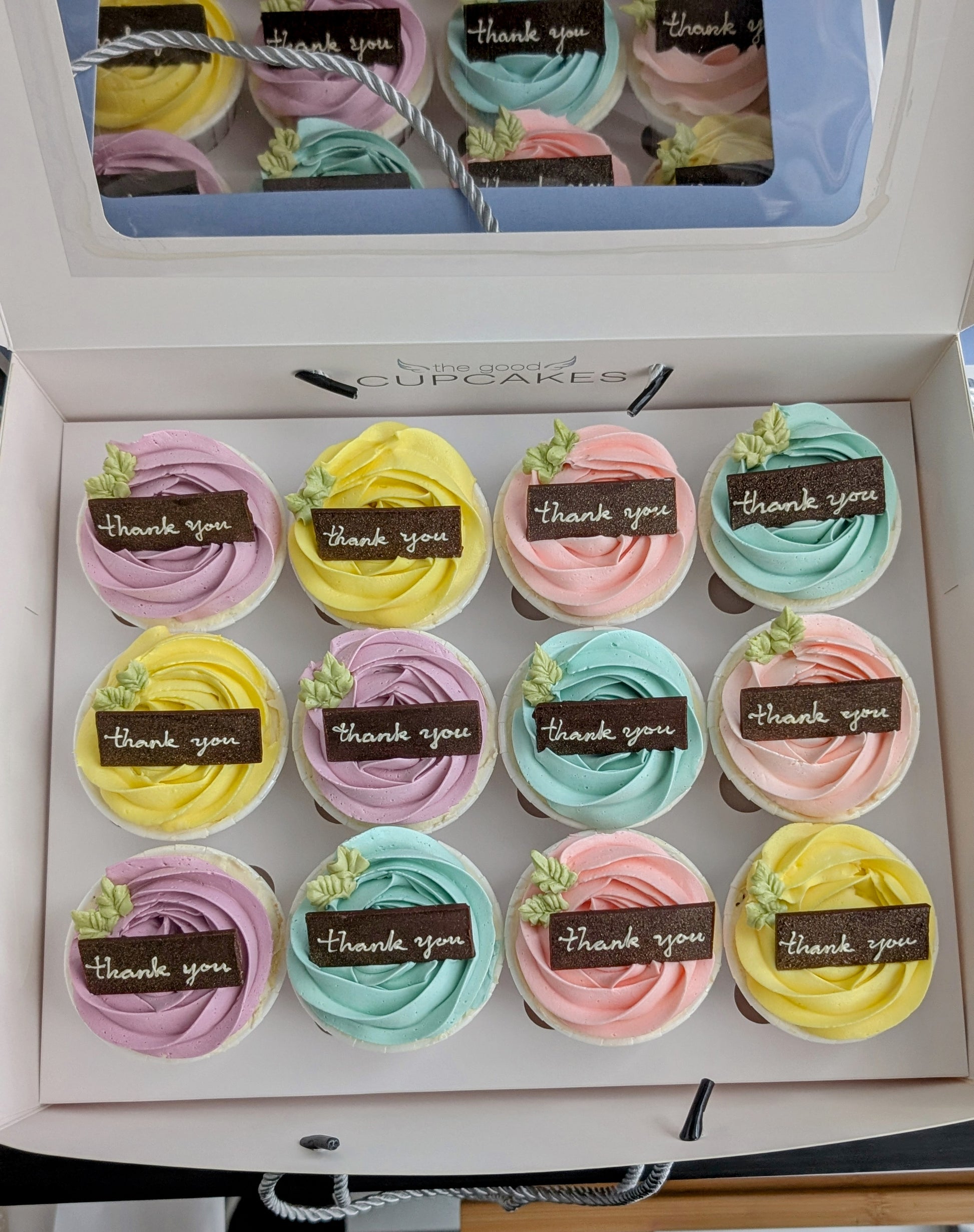 Box of 12 pastel rose buttercream cupcakes with handcrafted chocolate "thank you" plaques in purple, yellow, pink and blue, The Good Cupcakes Singapore

