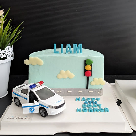 blue buttercream police car birthday cake with police car topper, piped traffic light and clouds, custom name topper, low-sugar kids birthday cake Singapore