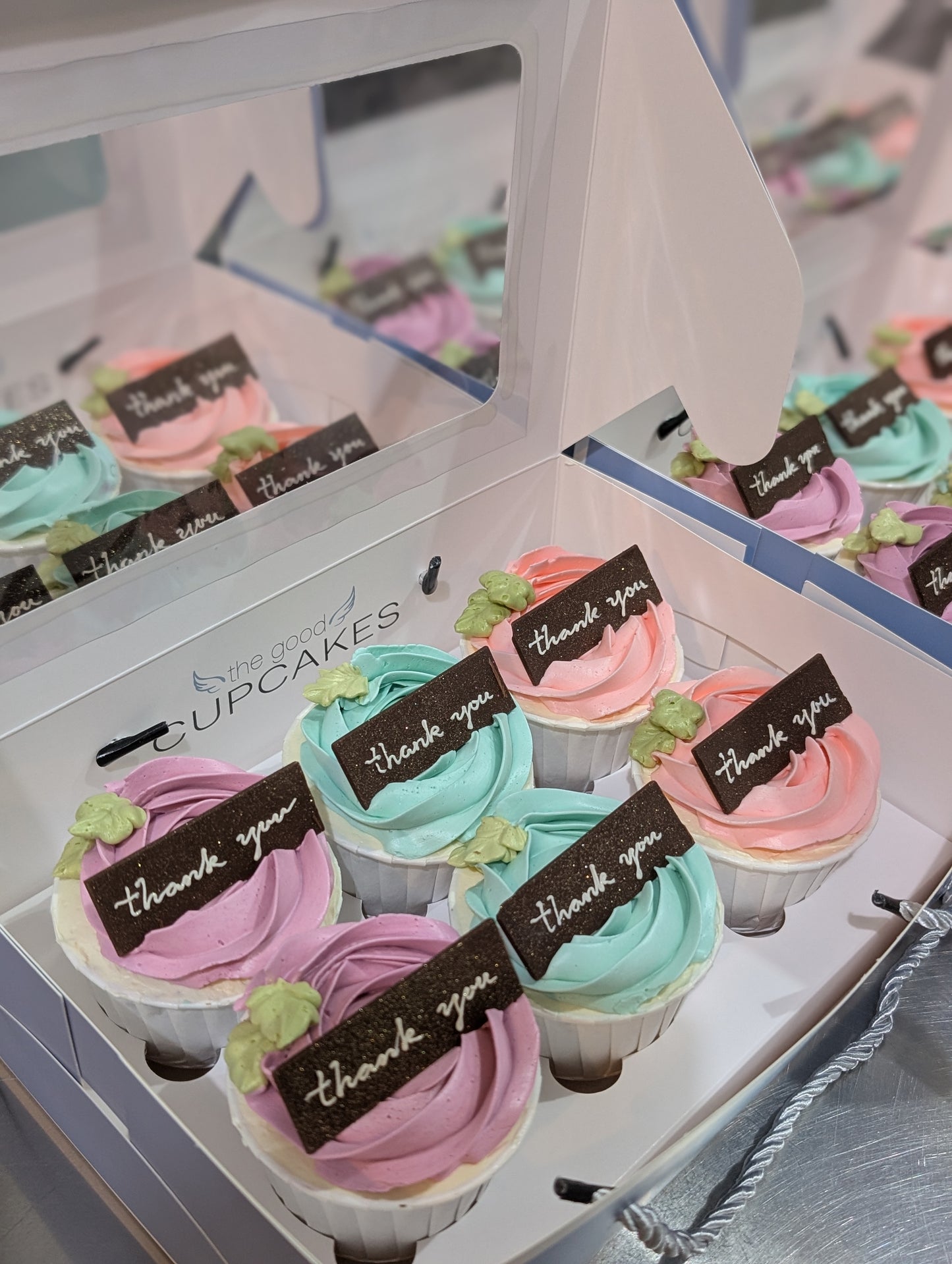Boxes of pastel rose buttercream cupcakes with handcrafted chocolate "thank you" plaques in purple, yellow, pink and blue, The Good Cupcakes Singapore

