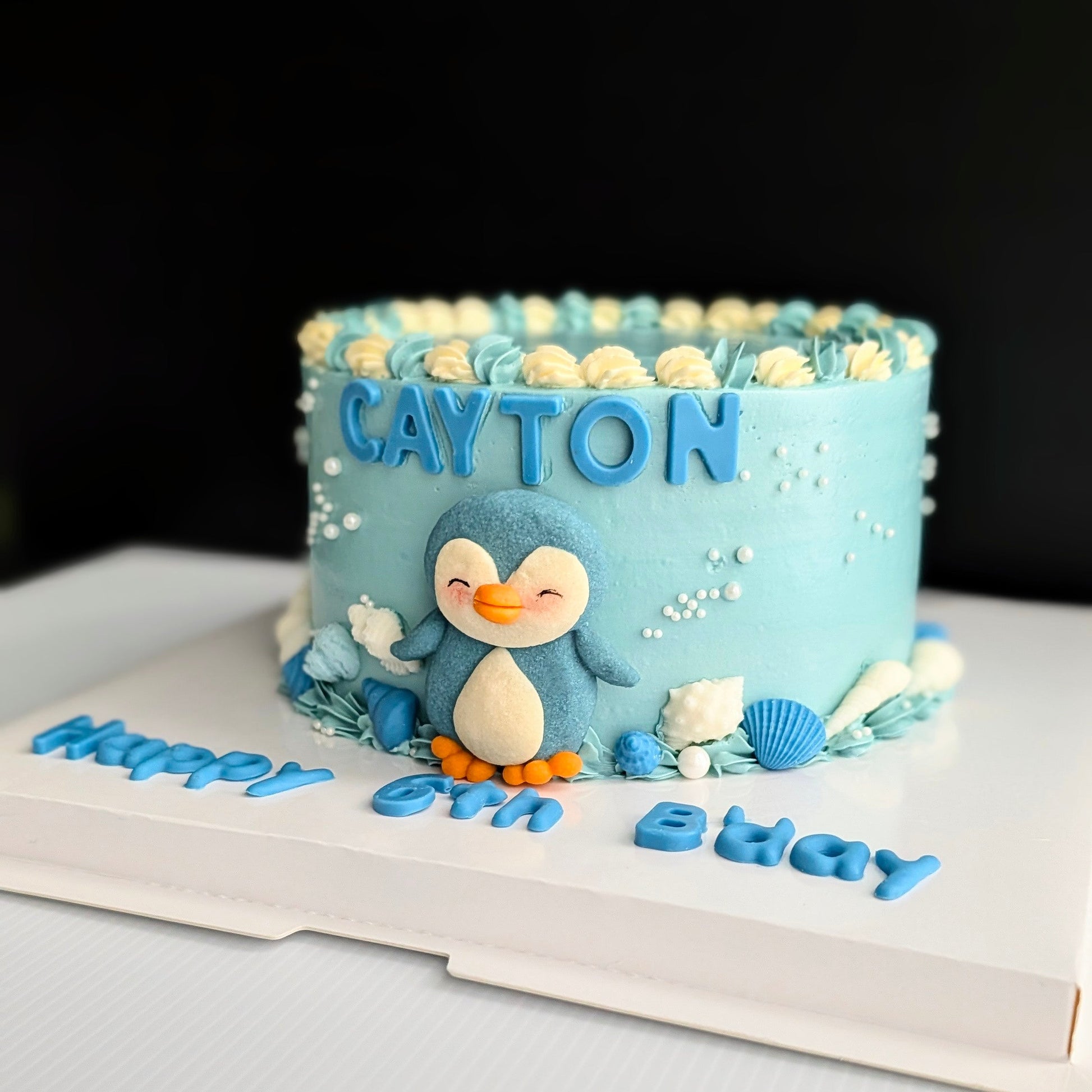 Blue ombre Penguin Cake with handcrafted shortbread cookie penguin, chocolate shell decorations and hand-piped buttercream, The Good Cupcakes Singapore