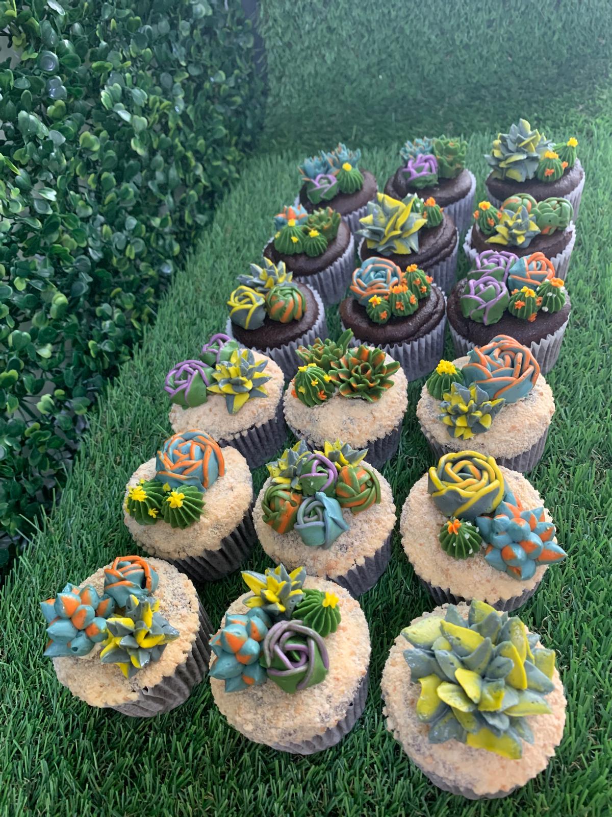 Succulent floral cupcakes arranged on artificial grass, teal, purple and orange buttercream cactus flowers — The Good Cupcakes Singapore