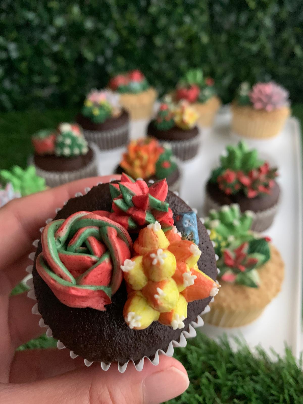 Hand holding a single succulent floral cupcake, red rose and green cactus buttercream piping detail — The Good Cupcakes Singapore