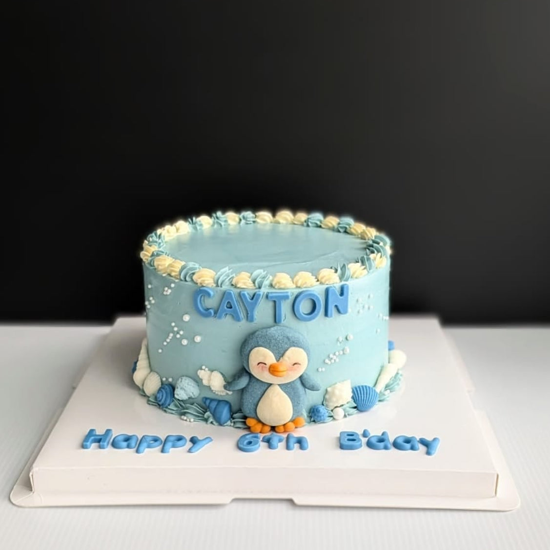 Blue ombre Penguin Cake with handcrafted shortbread cookie penguin, chocolate shell decorations and hand-piped buttercream, The Good Cupcakes Singapore