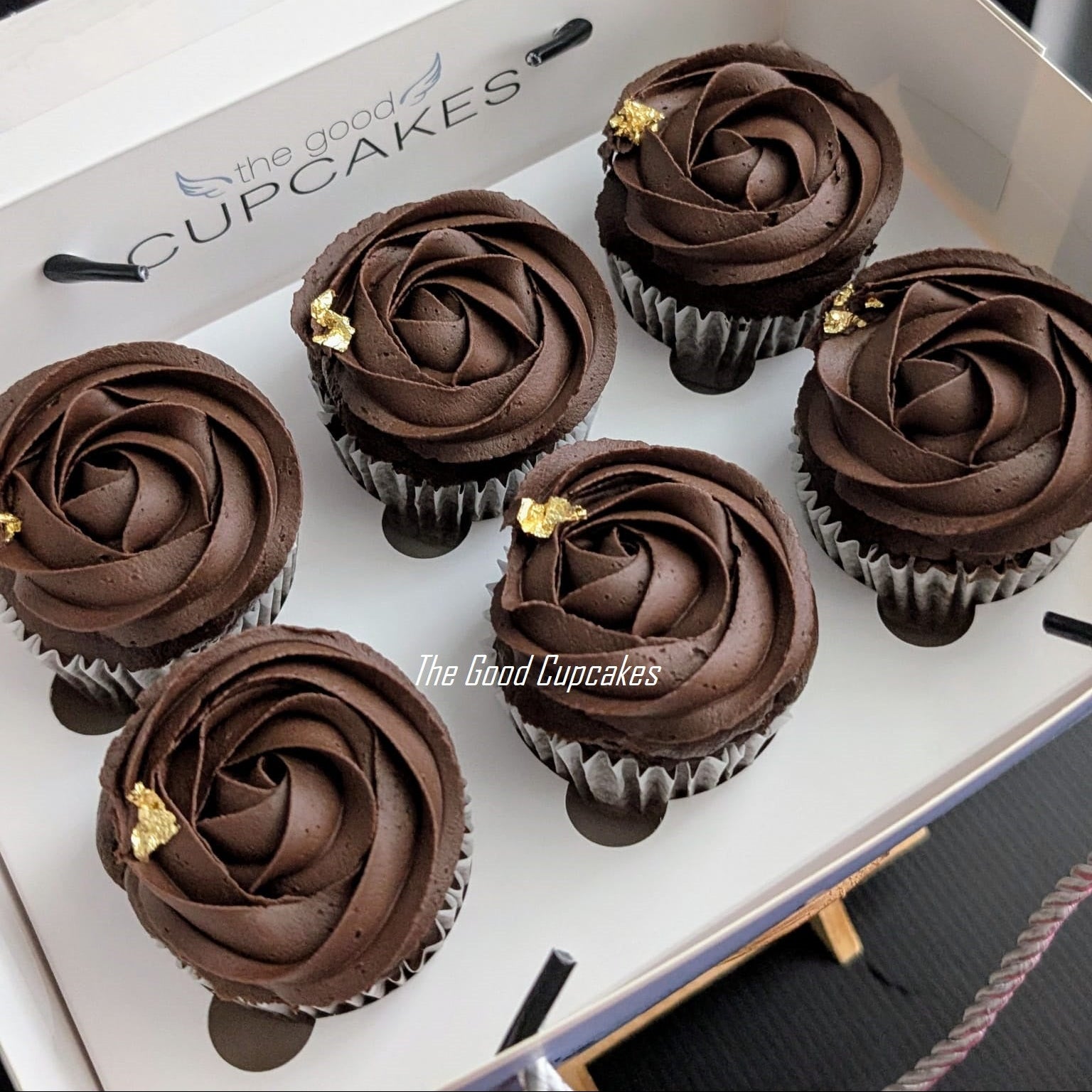 
Box of 6 chocolate cupcakes with swirled dark chocolate frosting and gold leaf flakes, The Good Cupcakes Singapore
