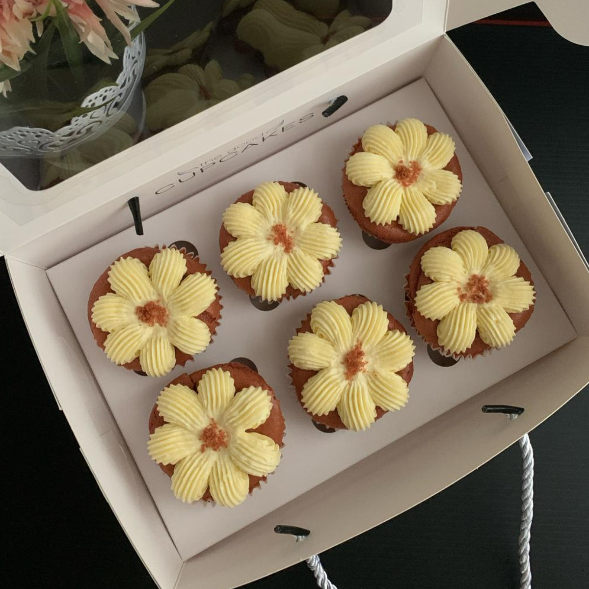 Red velvet cupcakes with flower-piped cream cheese frosting and red velvet crumble, 150 calories each