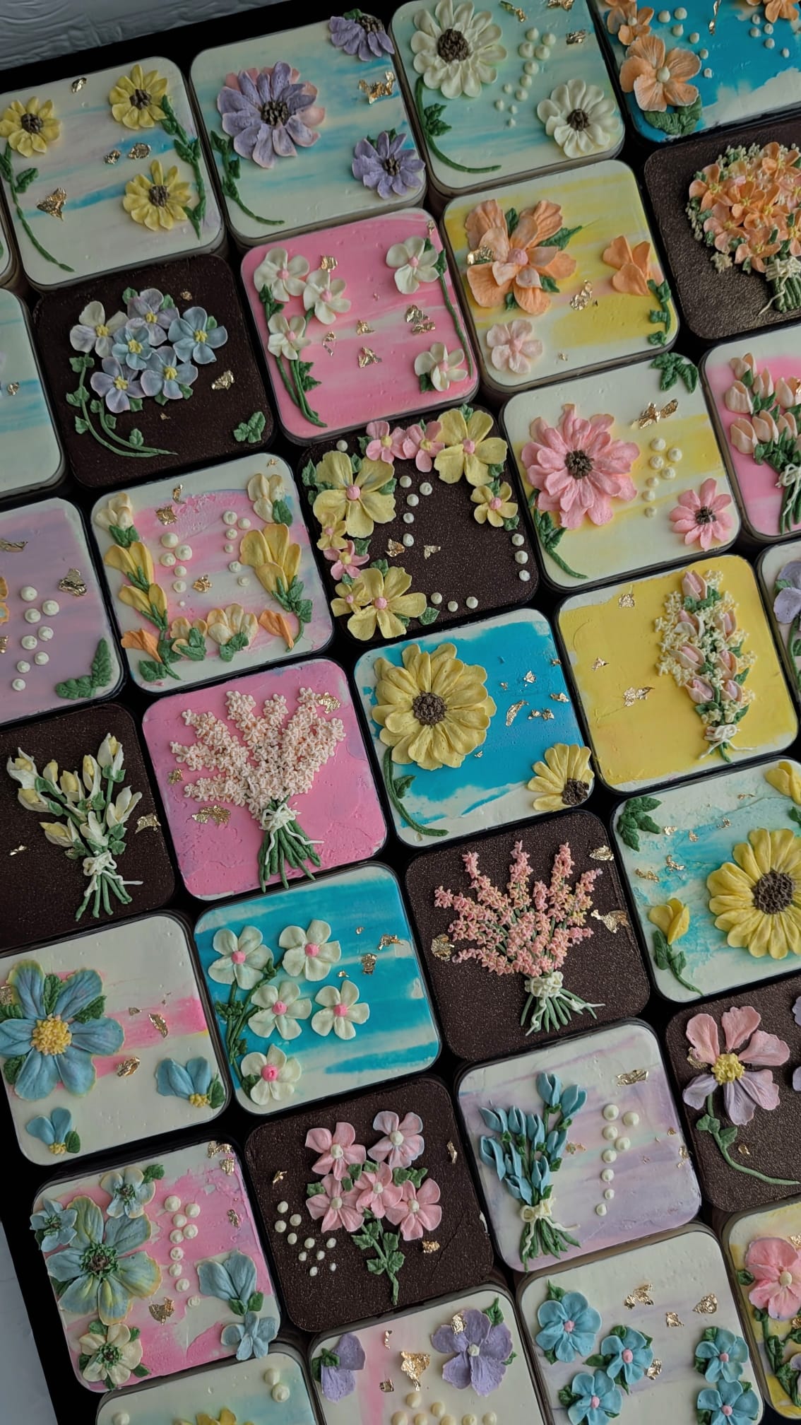 Floral bento boxed cakes with hand-piped buttercream flowers on pastel painted backgrounds, healthy low-sugar mini cakes Singapore