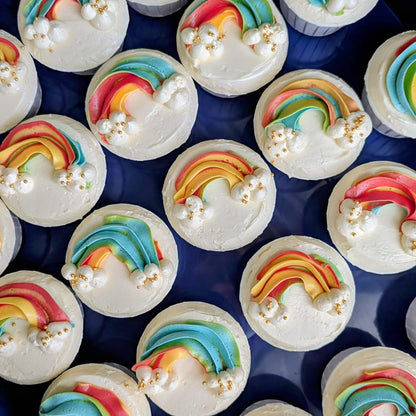 Close-up of custom rainbow cupcake with colourful hand-piped buttercream design